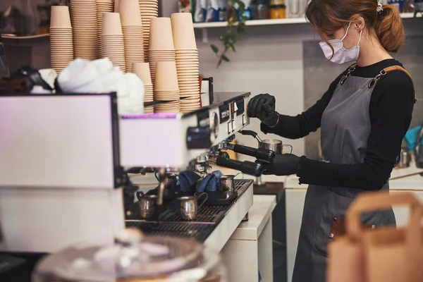 Barista femenina ocupada operando la máquina de café y haciendo bebidas calientes —  Fotos de Stock