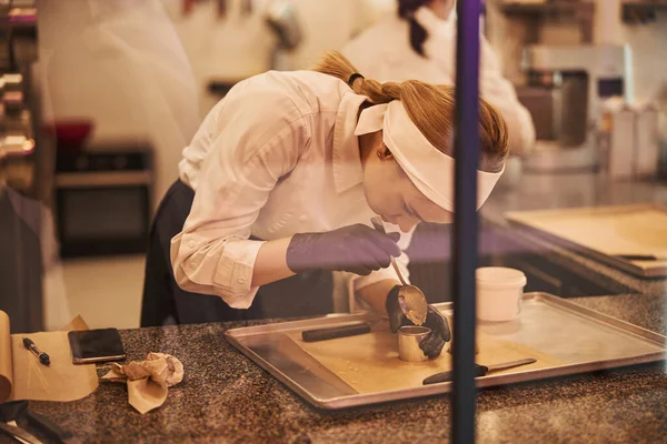 Mujer enfocada en uniforme de chef trabajando duro en la fabricación de postres — Foto de Stock