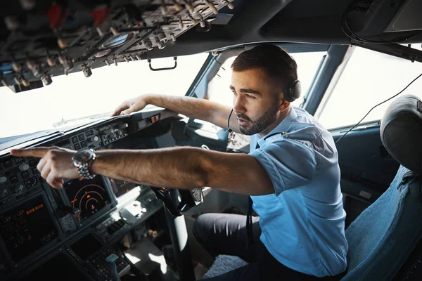 Orolig ung pilot pekar på något utanför flygplanet — Stockfoto