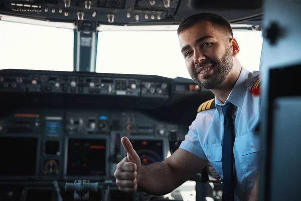 Tillfredsställd manlig pilot som visar sitt självförtroende före flygningen — Stockfoto