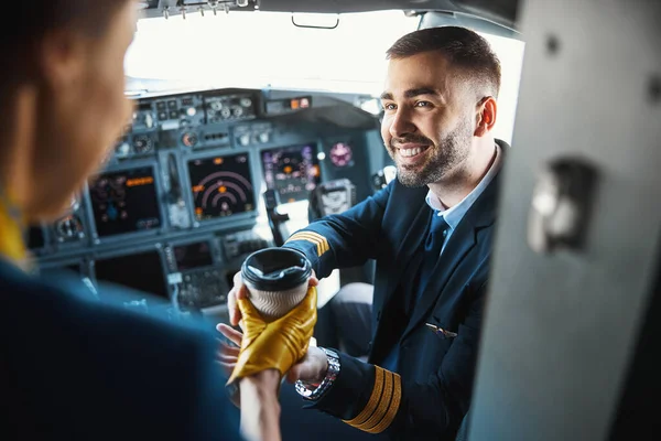 Gladsome pilota ottenere bevanda calda prima del volo — Foto Stock