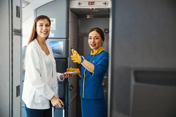 Feliz joven entrando en el avión de pasajeros y sonriendo — Foto de Stock