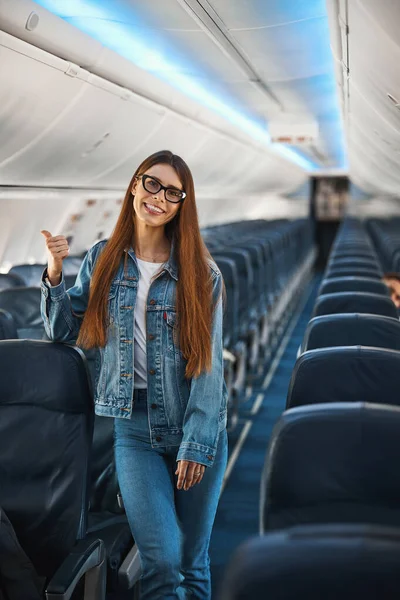 Mooie jonge vrouw die alleen in het passagiersvliegtuig staat — Stockfoto