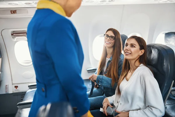 Tevreden vriendelijke passagiers die laten zien hoe ze de regels volgen — Stockfoto