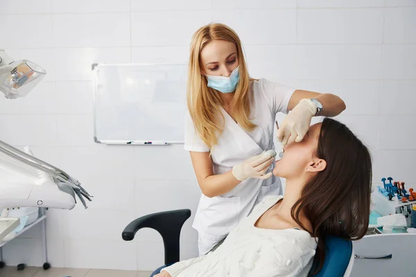 Dentista poniendo piedra de masilla en la boca del paciente para impresión dental —  Fotos de Stock