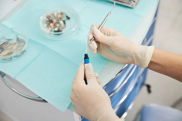 Medik dává zubní zástrčku do lahvičky s kompozitními pryskyřicemi — Stock fotografie