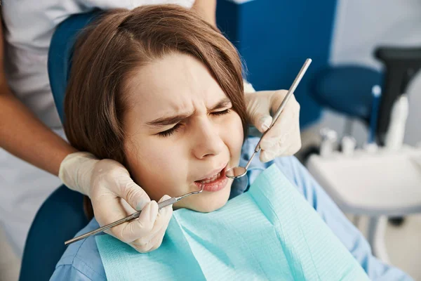 Пациент щурясь от страха перед зубными инструментами — стоковое фото