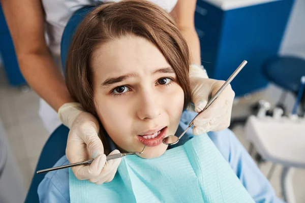 Scared kid looking pitifully in camera during dental examination Royalty Free Stock Images