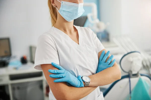Gekruiste handen van tandheelkundige chirurg staan trots in haar kliniek — Stockfoto