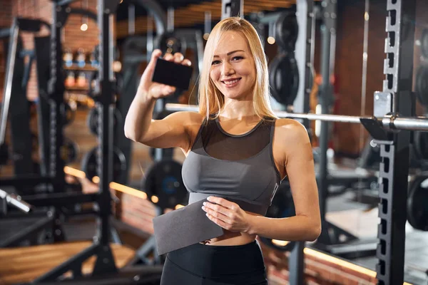 Alegre deportista mostrando papel en blanco a la cámara — Foto de Stock