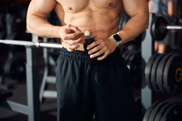 Shapely sportsman showing the right dosage of protein powder — Stock Photo, Image