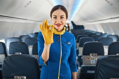 Kendine güvenen bayan hostes iş yerinde iyi niyet gösterisi gösteriyor.