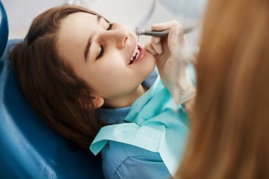 İşlem sırasında diş matkabı altında yatan hevesli çocuk