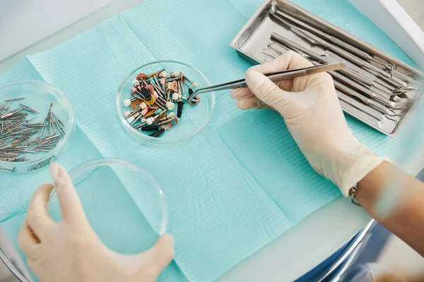 Doctor overbrengen tandheelkundige polijsten borstel van de ene plaat naar de andere — Stockfoto