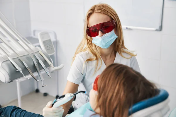 Rellenos compuestos de ajuste médico de mujer con luces de curado dental —  Fotos de Stock