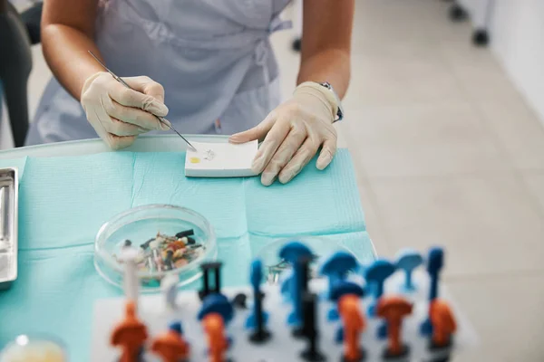 Persoon die tandvullingen produceert uit poeder en druppel olie — Stockfoto