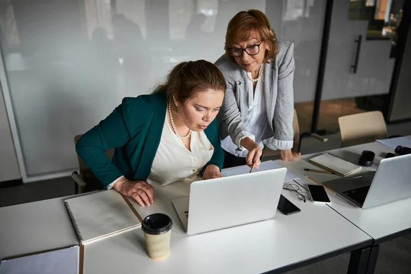 Arbeiter starrt auf Laptop, Chef zeigt Bleistift auf Bildschirm — Stockfoto