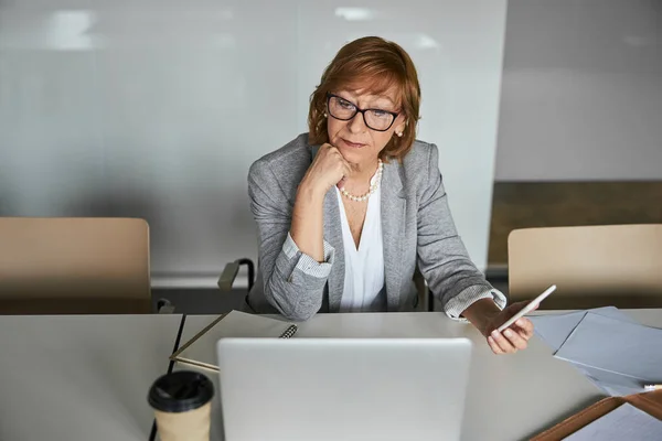 Seriöser Geschäftsinhaber hört Person auf Laptop zu — Stockfoto