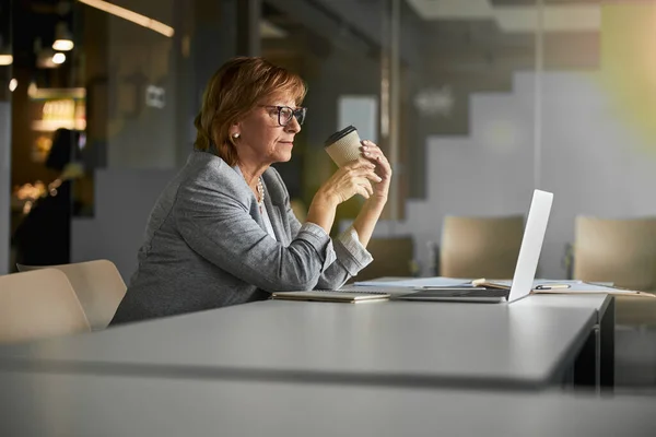 Mujer de negocios bebiendo café delante de la computadora portátil — Foto de Stock