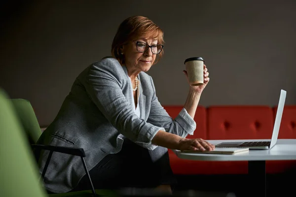 Charmante reife weibliche Person nimmt ihr Notizbuch — Stockfoto