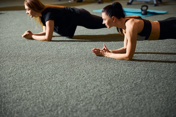 Duas mulheres aptas a se exercitar em resistência e fazer pranchas — Fotografia de Stock