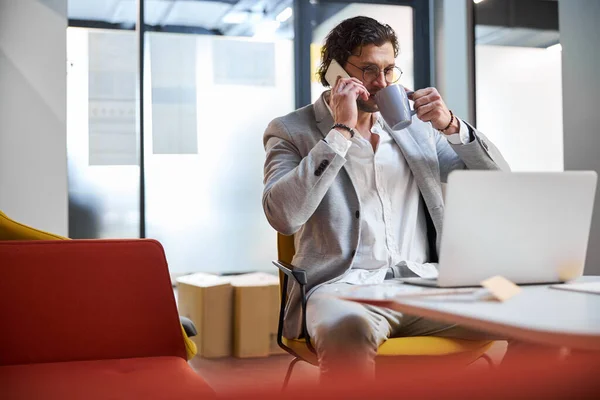 Hombre de negocios relajado bebiendo café mientras toma un descanso — Foto de Stock