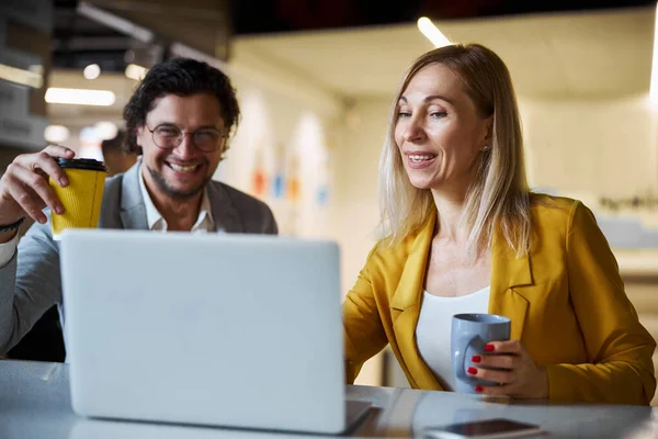 Nahaufnahme einer fröhlichen Frau, die neben ihrem Kollegen sitzt — Stockfoto