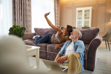 Telefonda fotoğraf çeken neşeli kadın.