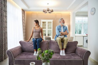 Üzgün esmer kadın pencereye bakıyor.