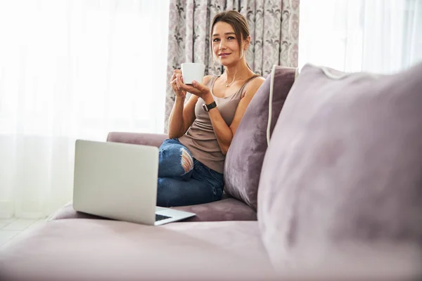 Persona femenina encantada positiva disfrutando de su té — Foto de Stock