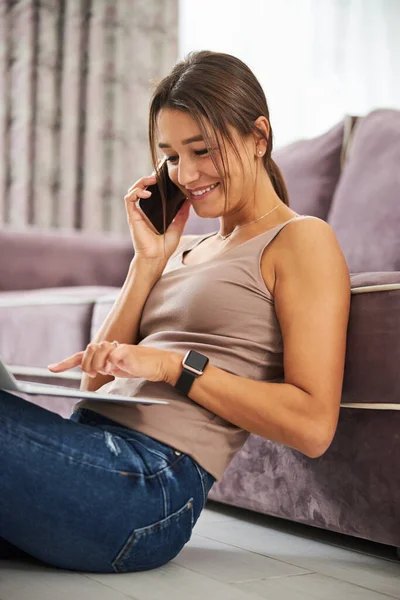 Mujer morena amable usando su computadora para el trabajo — Foto de Stock