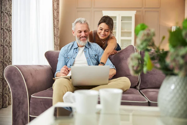 Güzel bir kadın dizüstü bilgisayarı işaret ediyor.