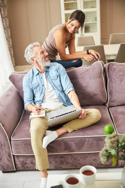 Nazik gri saçlı adam kız arkadaşını dinliyor.