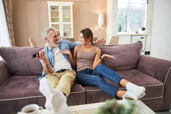 Memnun sakallı adam ortağına bakıyor.