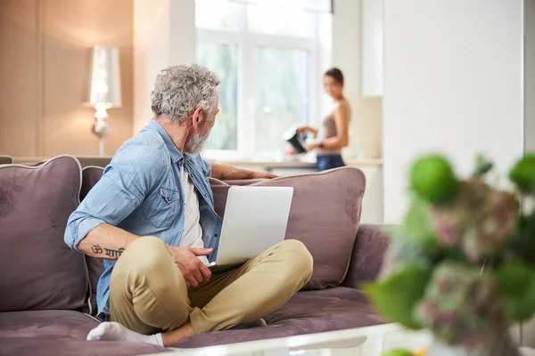 Kind grey-haired man turning head to his partner — Stock Photo, Image