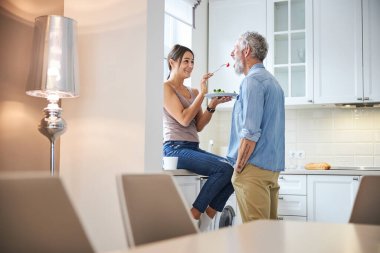 Nazik sakallı adam öğle yemeğini evde yiyor.