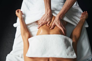 Güzellik salonunda müşteri karnına yeni masaj tekniği uygulayın.