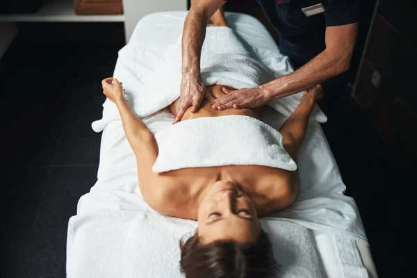 Onbekende ervaren massagetherapeut die manuele therapie maakt in het wellnesscentrum — Stockfoto