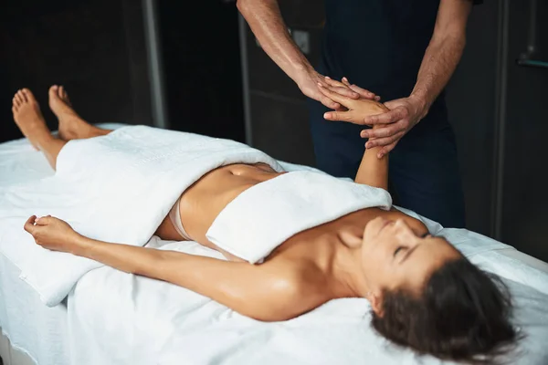 Mooie jonge Kaukasische vrouw onder de handdoek rusten bij de nieuwe massage techniek in gezondheidscentrum — Stockfoto