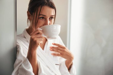 Elinde beyaz bardakla güzel bir bayan Güzellik salonunda iyi hafta sonları.