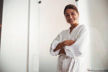 Güzel, zarif, beyaz bir kadın. Spa salonundaki fotoğraf makinesine poz veriyor ve bakıyor.