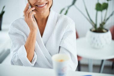 Cep telefonuyla konuşan memnun bir spa müşterisi.