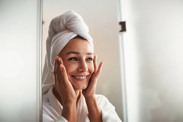 Glad glad glad ung kaukasiska kvinna i vit badrock och handduk på huvudet vilar i spa relax komplex — Stockfoto