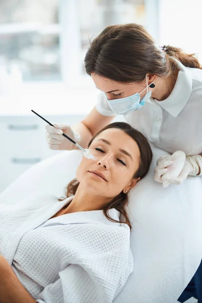 Cosmetólogo calificado realizando un procedimiento de rejuvenecimiento facial — Foto de Stock