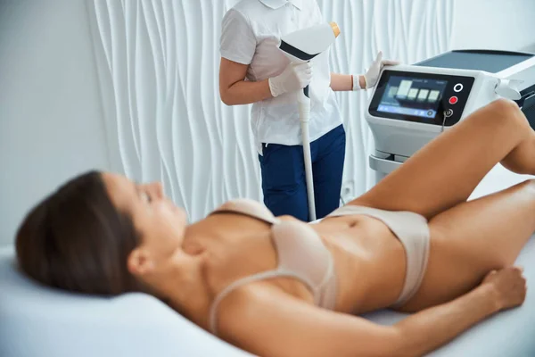 Qualified cosmetician preparing a young patient for a cosmetic procedure — Stock Photo, Image