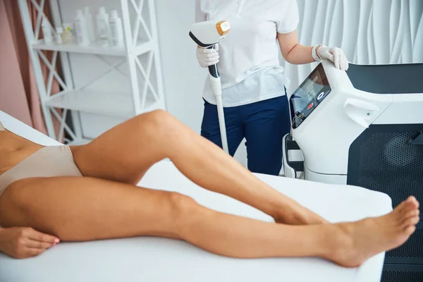Médico preparando a una mujer para un tratamiento de depilación láser — Foto de Stock