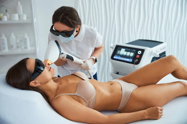 Smiling patient undergoing the facial laser hair removal — Stock Photo, Image