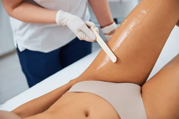 Dermatólogo aplicando un gel sobre la piel femenina con una espátula — Foto de Stock