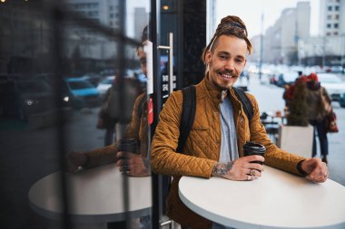 Şehirde sabah kahvesinin tadını çıkaran mutlu bir insan.