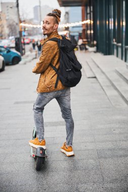 Yakışıklı genç adam sokakta sana dönüyor ve gülümsüyor.